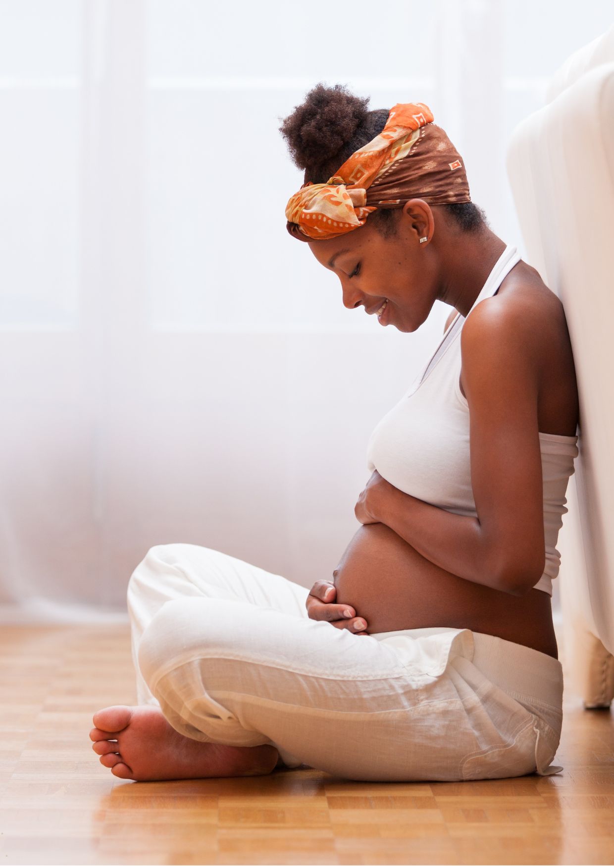 Pregnant woman sitting quietly with her hands resting on her bump